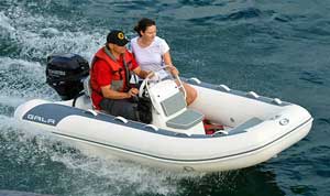 Crew boating in the bay on a 10ft Gala aluminum rigid inflatable boat (RIB) equipped with a steering console, seating, and Tohatsu outboard motor.