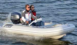 Couple boating on the lake in a 10ft Gala aluminum rigid inflatable boat (RIB) equipped with an Aquahelm steering console, seating, and outboard motor.