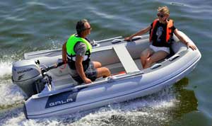 Couple boating on the lake in a Gala aluminum rigid inflatable boat (RIB) equipped with seating, front locker, and Honda outboard motor.