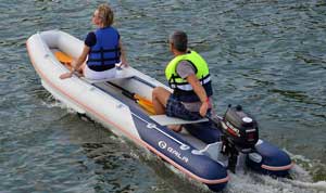 Couple boating on the lake in a Gala 13ft foldable inflatable canoe boat equipped with a Suzuki outboard motor.