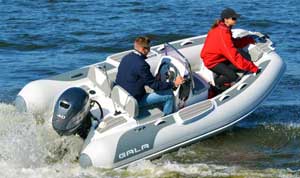 Couple riding along the shoreline in a luxury 12ft Gala rigid inflatable boat tender equipped with a 40HP Yamaha outboard motor.