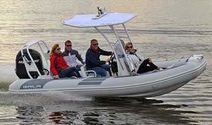 Couples boating on the lake in a 17ft Gala aluminum rigid inflatable boat RIB rigged with a steering console, seating, & Mercury outboard motor.